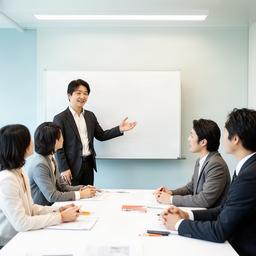 会議形式の研修でホワイトボードを使う日本人講師、参加者と合意形成を進める様子